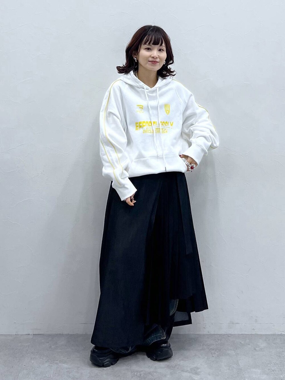 ブラック系のブーツ、ブルー系のデニムパンツ、ブラック系のスカートを着用したレディースの冬コーディネートの6枚目の写真