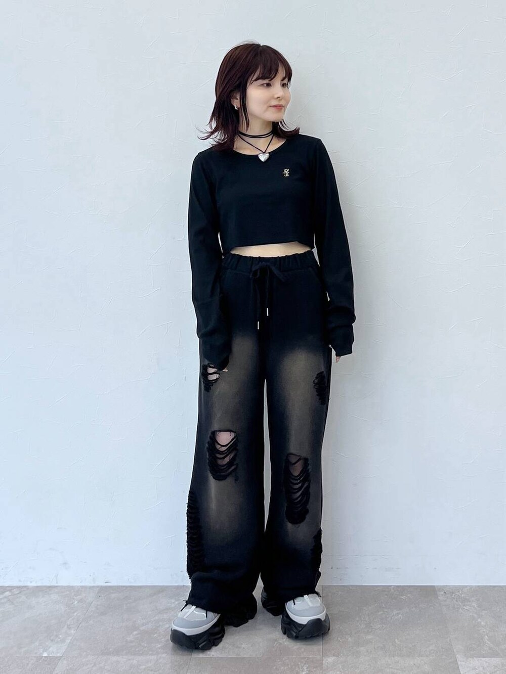 グレー系のスニーカー、ブラック系のスウェットパンツ、ブラック系のTシャツ/カットソーを着用したレディースの秋コーディネートの2枚目の写真