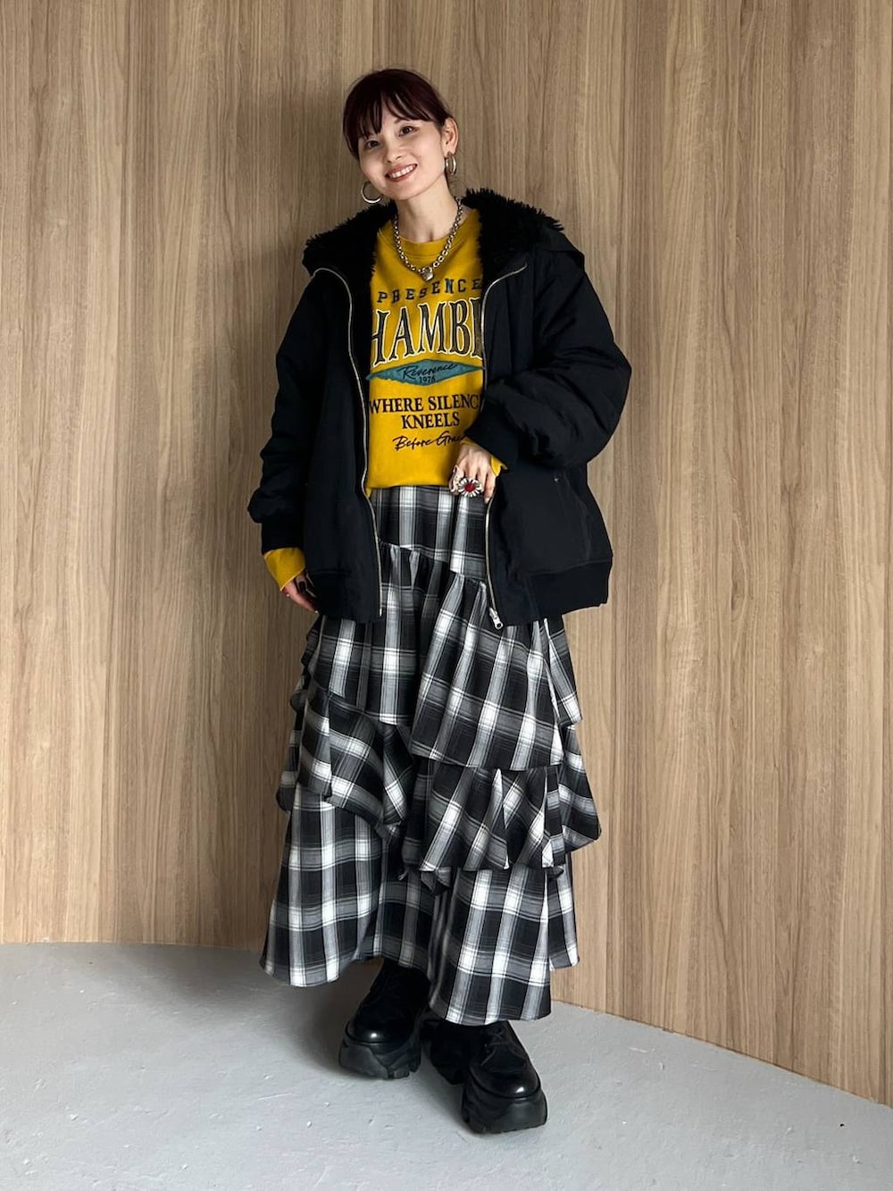 ブラック系のブーツ、イエロー系のスウェット、ブラック系のブルゾンを着用したレディースの秋コーディネートの6枚目の写真