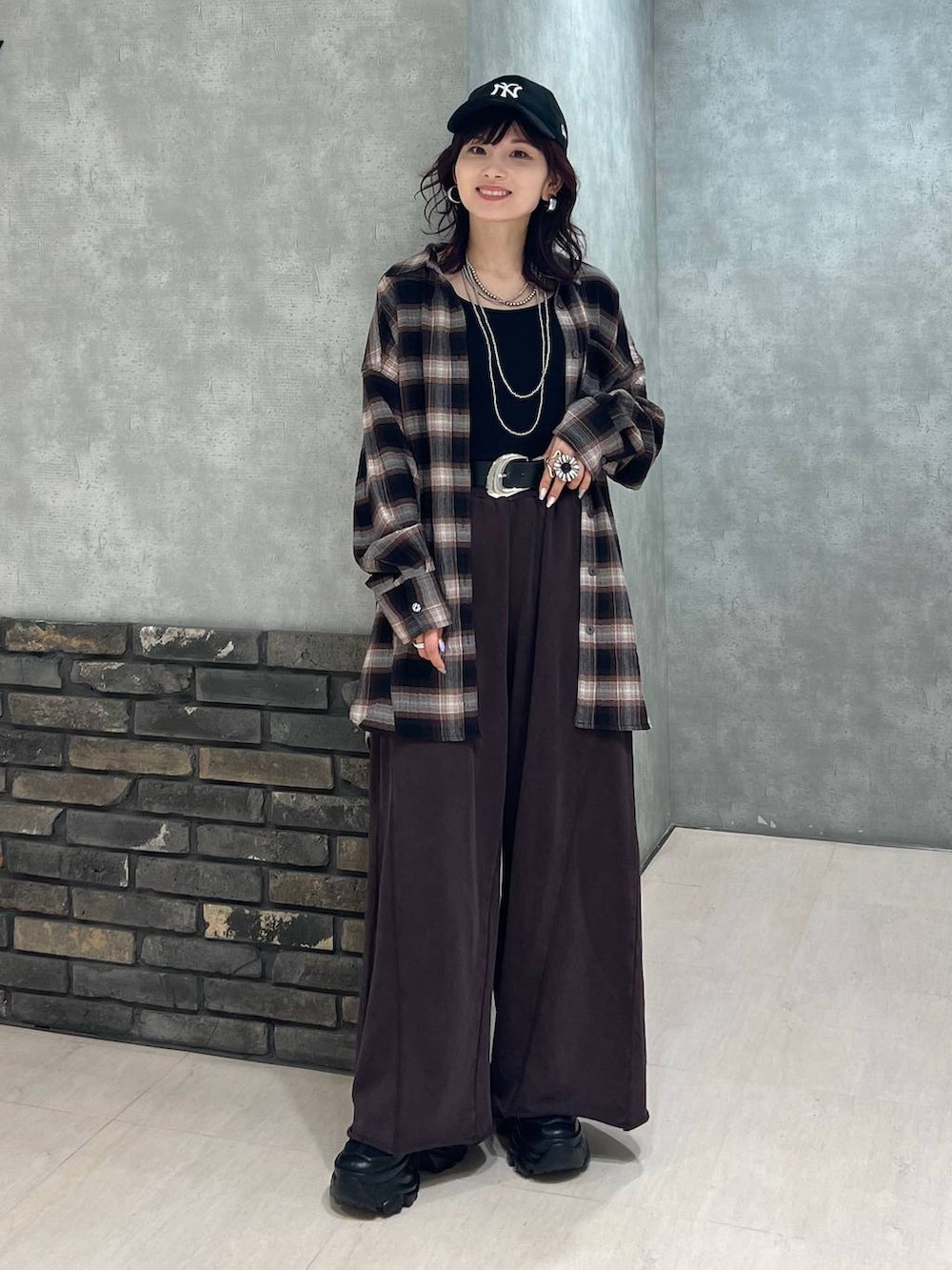 ブラック系のブーツ、ブラウン系のスウェットパンツ、ブラウン系のシャツ/ブラウスを着用したレディースの秋コーディネートの3枚目の写真