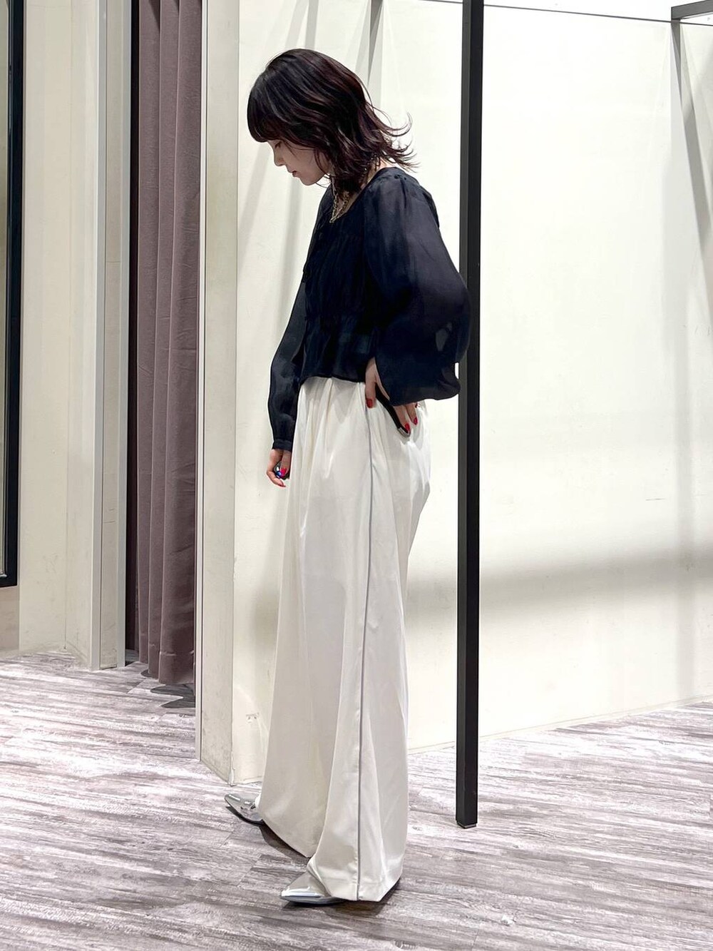 シルバー系のパンプス、ホワイト系のスラックス、ブラック系のシャツ/ブラウスを着用したレディースの春コーディネートの3枚目の写真