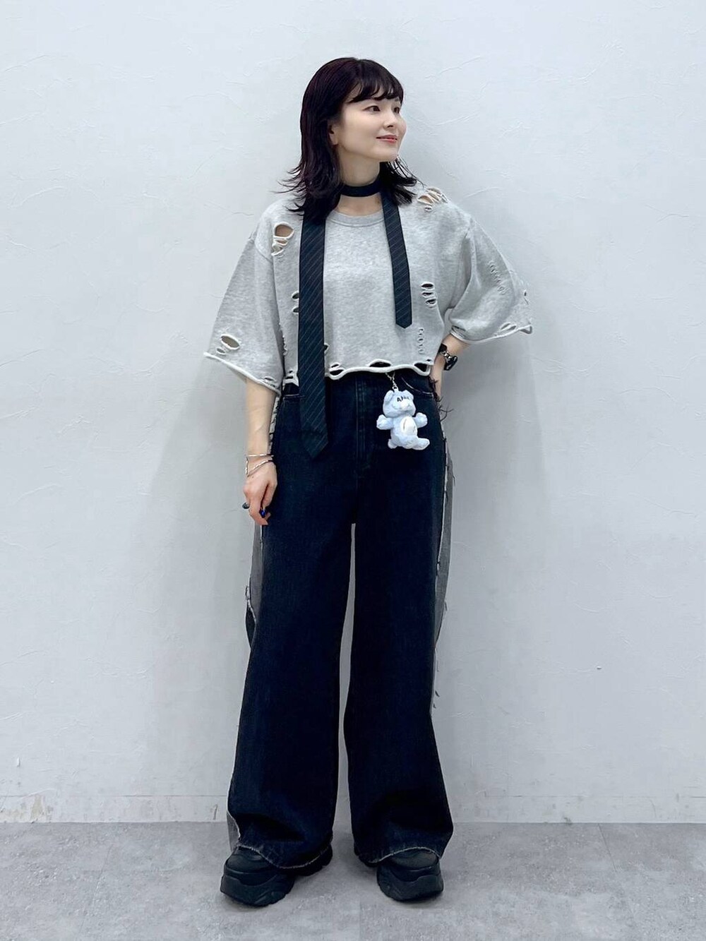 グレー系のネクタイ、ブラック系のスニーカー、ブルー系のデニムパンツを着用したレディースの夏コーディネートの2枚目の写真