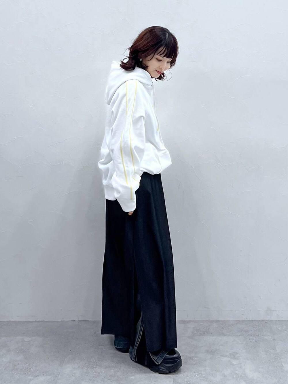 ブラック系のブーツ、ブルー系のデニムパンツ、ブラック系のスカートを着用したレディースの冬コーディネートの3枚目の写真