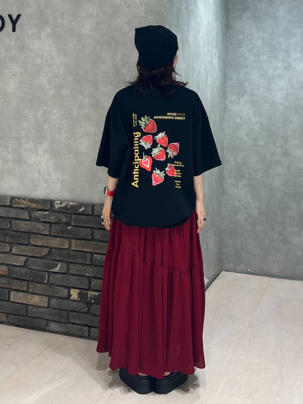 ブラック系のTシャツ/カットソー、レッド系のスカート、ブラック系のニットキャップ/ビーニーを着用したレディースの夏コーディネートの5枚目の写真