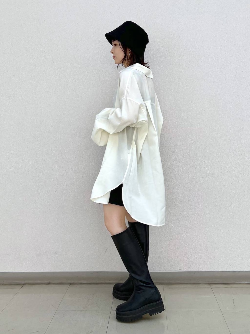 ブラック系のブーツ、ホワイト系のシャツ/ブラウス、ブラック系のスカートを着用したレディースの秋コーディネートの2枚目の写真