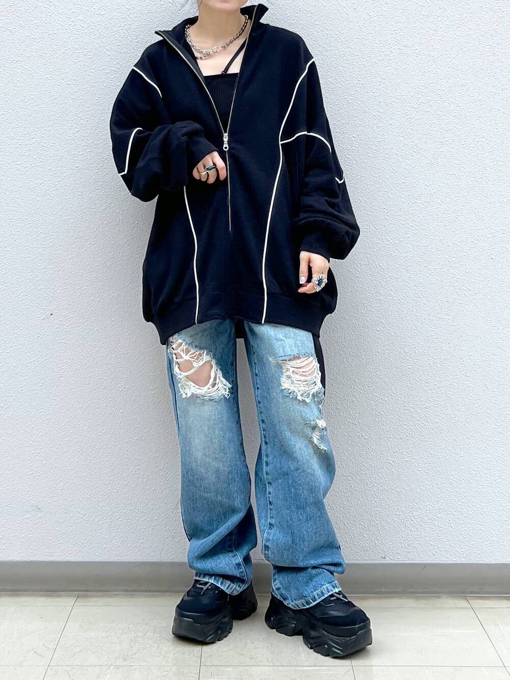 ブラック系のキャミソール、ブルー系のデニムパンツ、ブラック系のスニーカーを着用したレディースの春コーディネートの7枚目の写真