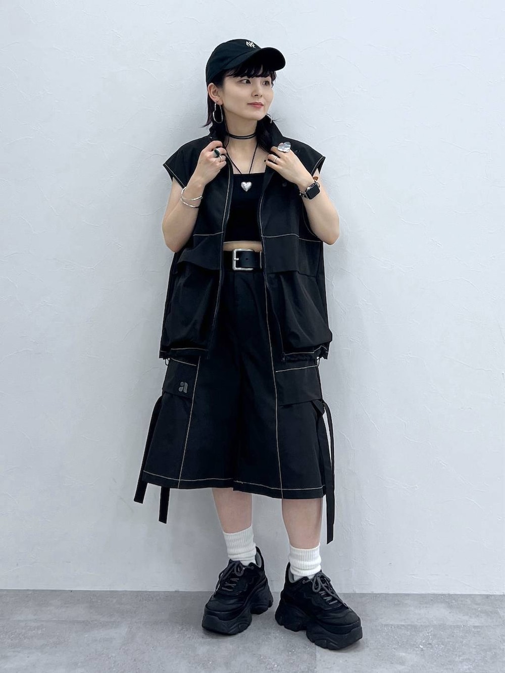 ブラック系のキャミソール、ブラック系のスニーカー、ブラック系のベストを着用したレディースの夏コーディネートの6枚目の写真