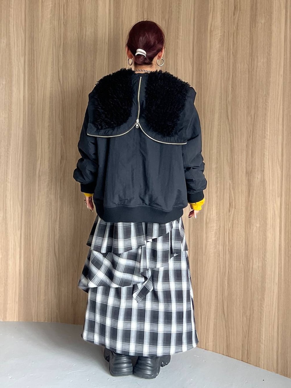 ブラック系のブーツ、イエロー系のスウェット、ブラック系のブルゾンを着用したレディースの秋コーディネートの3枚目の写真