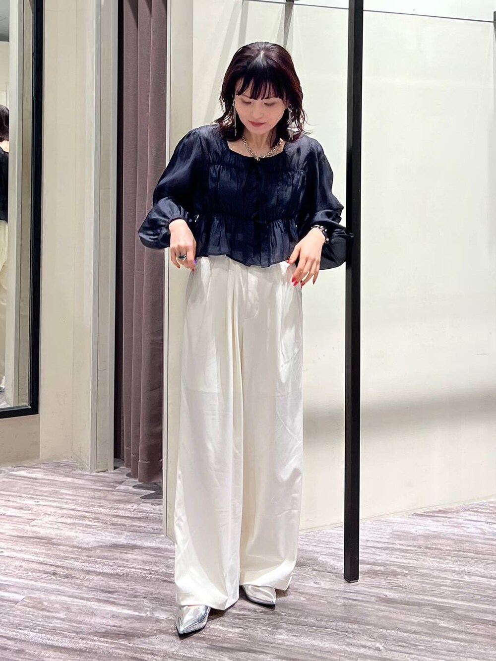 シルバー系のパンプス、ホワイト系のスラックス、ブラック系のシャツ/ブラウスを着用したレディースの春コーディネートの5枚目の写真