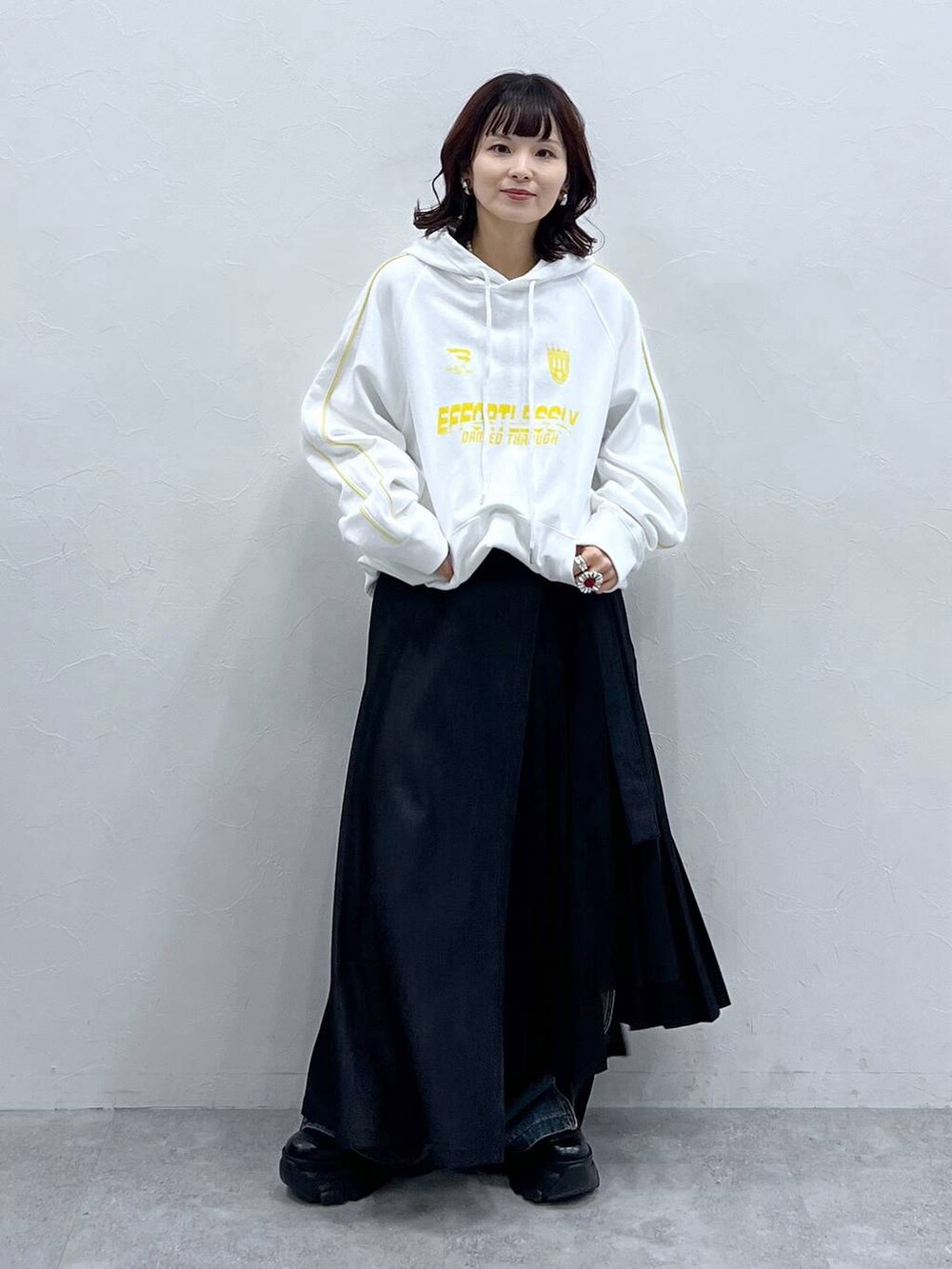 ブラック系のブーツ、ブルー系のデニムパンツ、ブラック系のスカートを着用したレディースの冬コーディネートの7枚目の写真