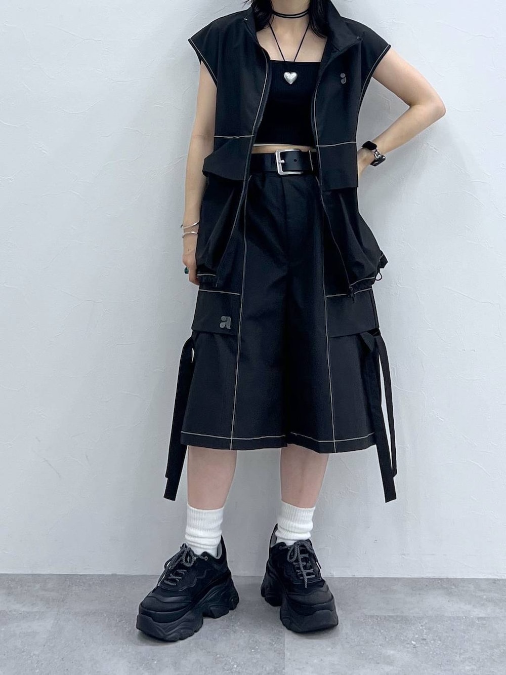 ブラック系のキャミソール、ブラック系のスニーカー、ブラック系のベストを着用したレディースの夏コーディネートの5枚目の写真