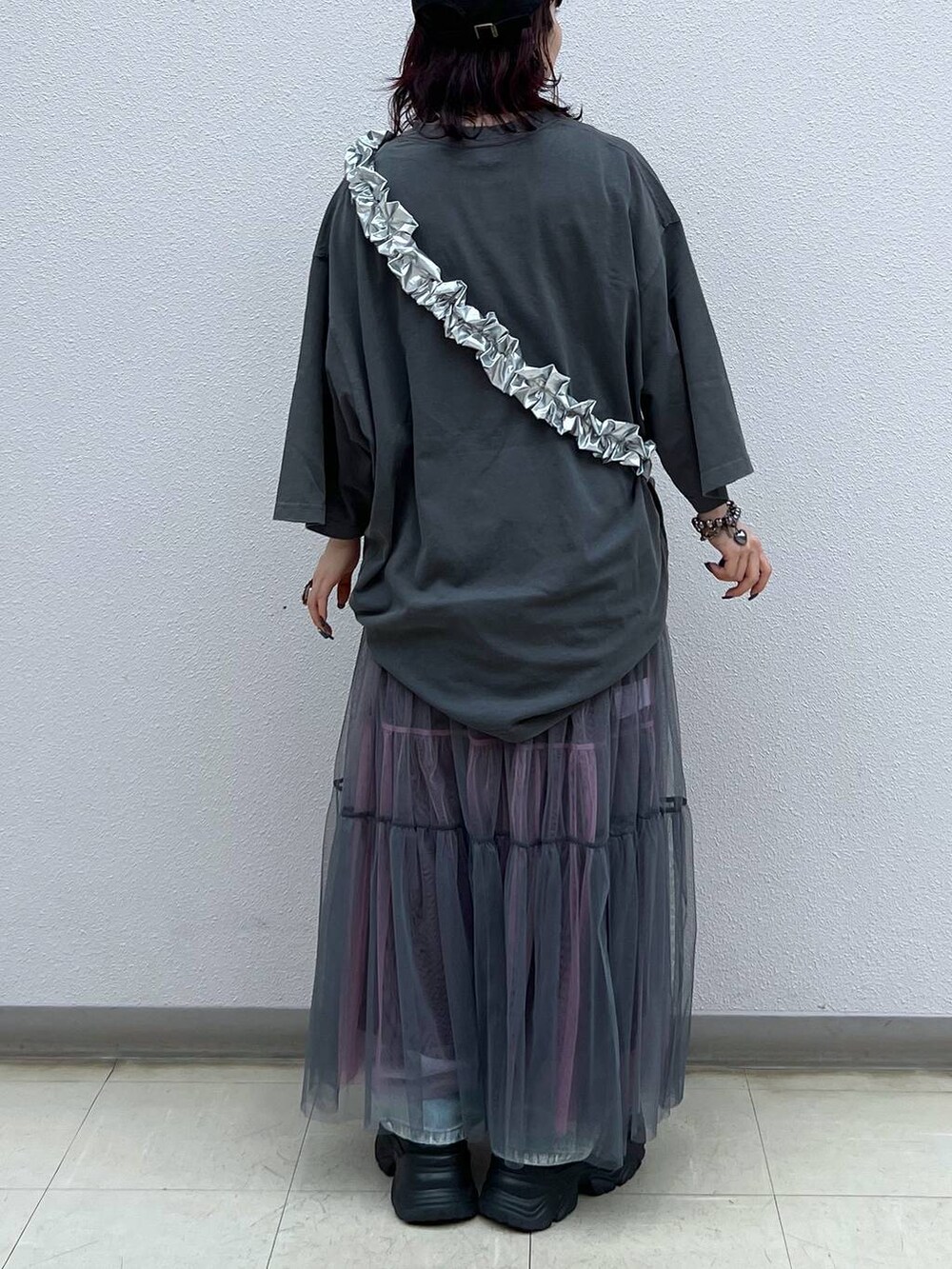 ブラック系のスニーカー、グレー系のスカート、ブルー系のデニムパンツを着用したレディースの夏コーディネートの5枚目の写真