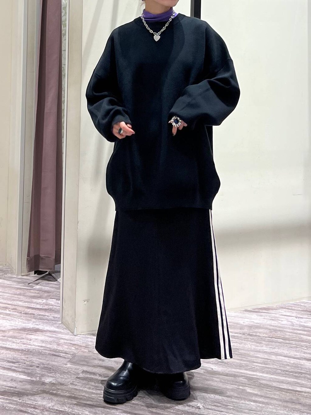 ブラック系のニット/セーター、パープル系のTシャツ/カットソー、ブラック系のスニーカーを着用したレディースの冬コーディネートの6枚目の写真