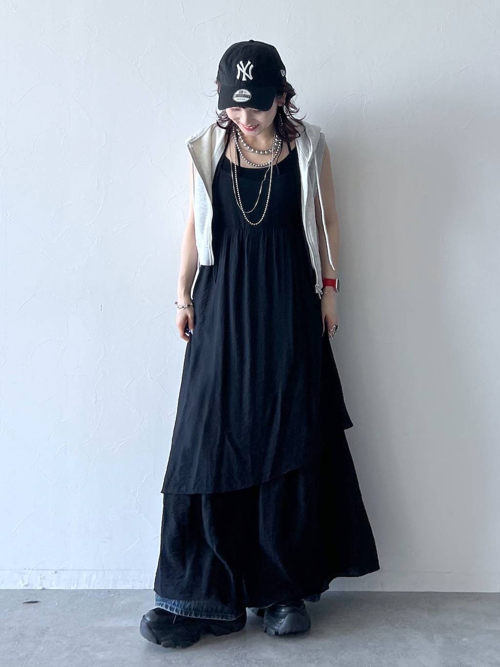 ブラック系のスニーカー、ブルー系のデニムパンツ、ブラック系のキャミソールを着用したレディースの夏コーディネートの6枚目の写真