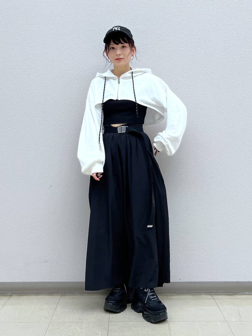 ブラック系のキャミソール、ブラック系のスニーカー、ホワイト系のパーカーを着用したレディースの秋コーディネートの6枚目の写真