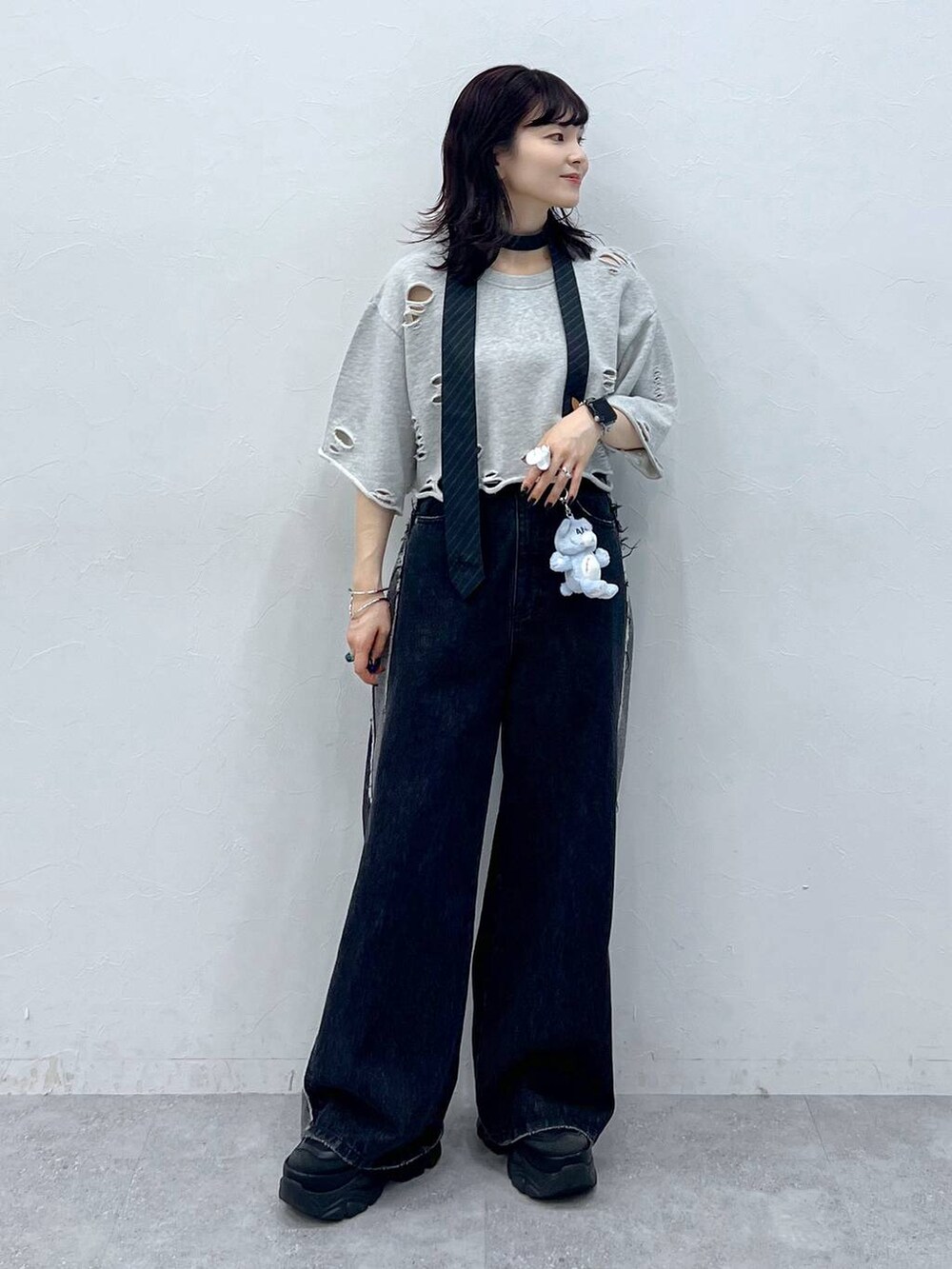 グレー系のネクタイ、ブラック系のスニーカー、ブルー系のデニムパンツを着用したレディースの夏コーディネートの6枚目の写真