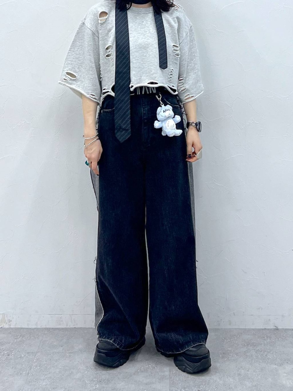 グレー系のネクタイ、ブラック系のスニーカー、ブルー系のデニムパンツを着用したレディースの夏コーディネートの5枚目の写真