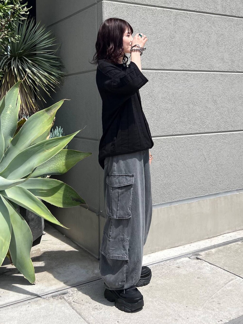 ブラック系のニット/セーター、ブラック系のスニーカー、ブラック系のデニムパンツを着用したレディースの夏コーディネートの3枚目の写真