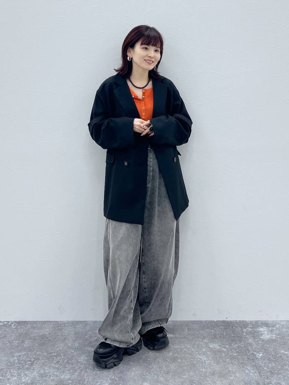 ブラック系のブーツ、ブラック系のテーラードジャケット、ブラック系のデニムパンツを着用したレディースの春コーディネートの2枚目の写真