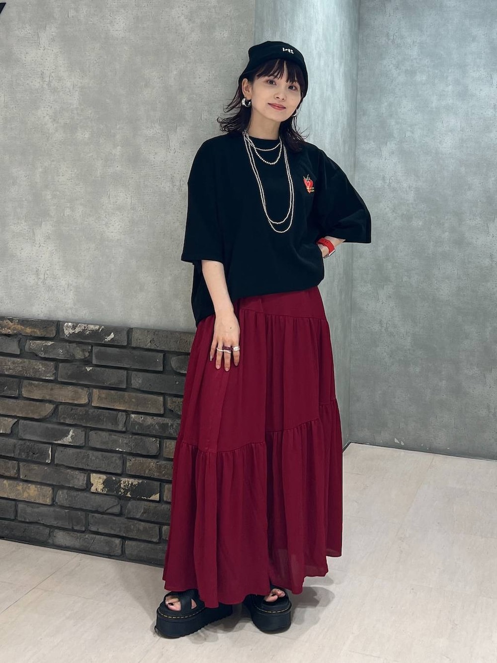 ブラック系のTシャツ/カットソー、レッド系のスカート、ブラック系のニットキャップ/ビーニーを着用したレディースの夏コーディネートの8枚目の写真