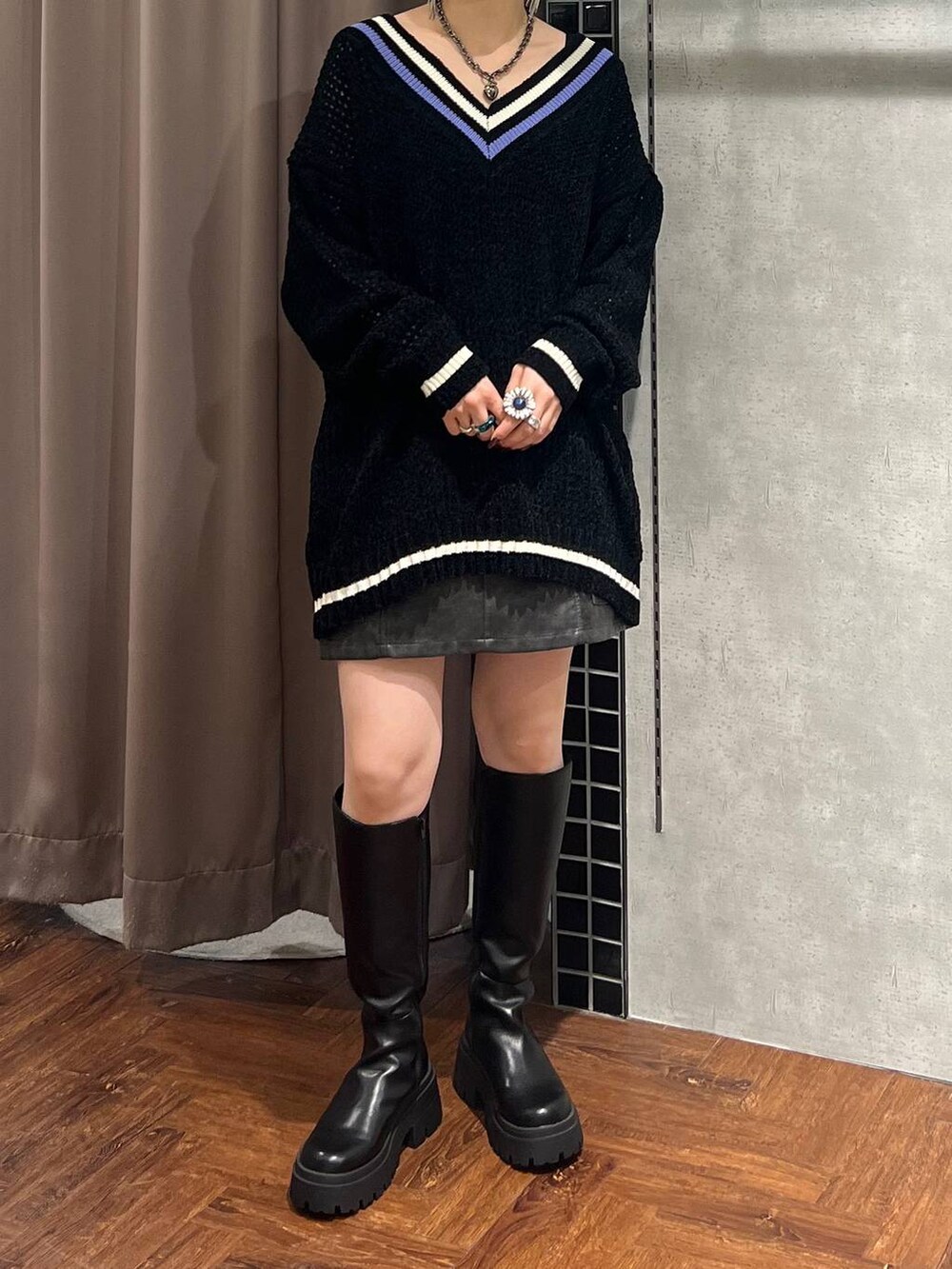 ブラック系のニット/セーター、ブラック系のスカート、ブラック系のブーツを着用したレディースの秋コーディネートの5枚目の写真