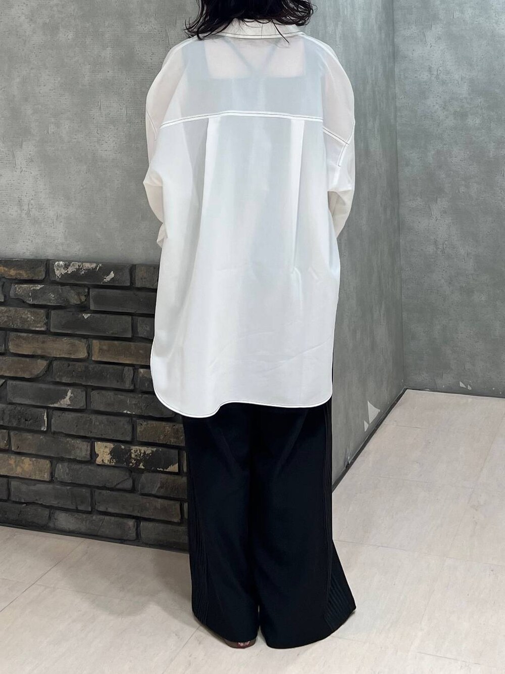 ブラック系のスラックス、ブラック系のタンクトップ、ブラック系のベルトを着用したレディースの春コーディネートの3枚目の写真