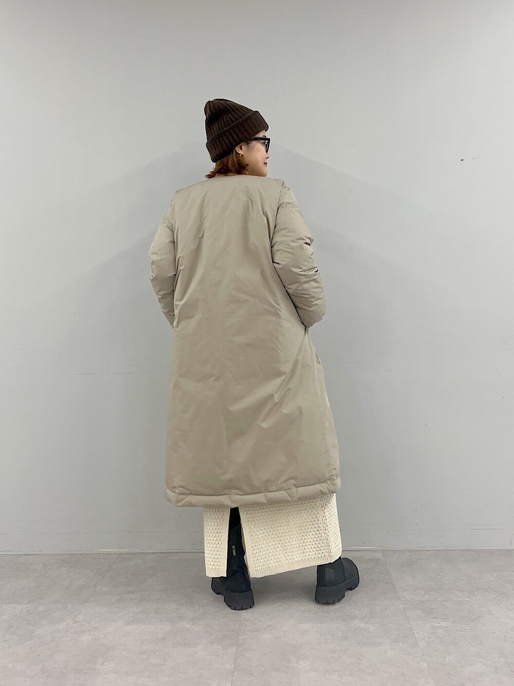 ベージュ系のその他アウター、ホワイト系のカーディガン/ボレロ、ホワイト系のスカートを着用したレディースの冬コーディネートの3枚目の写真