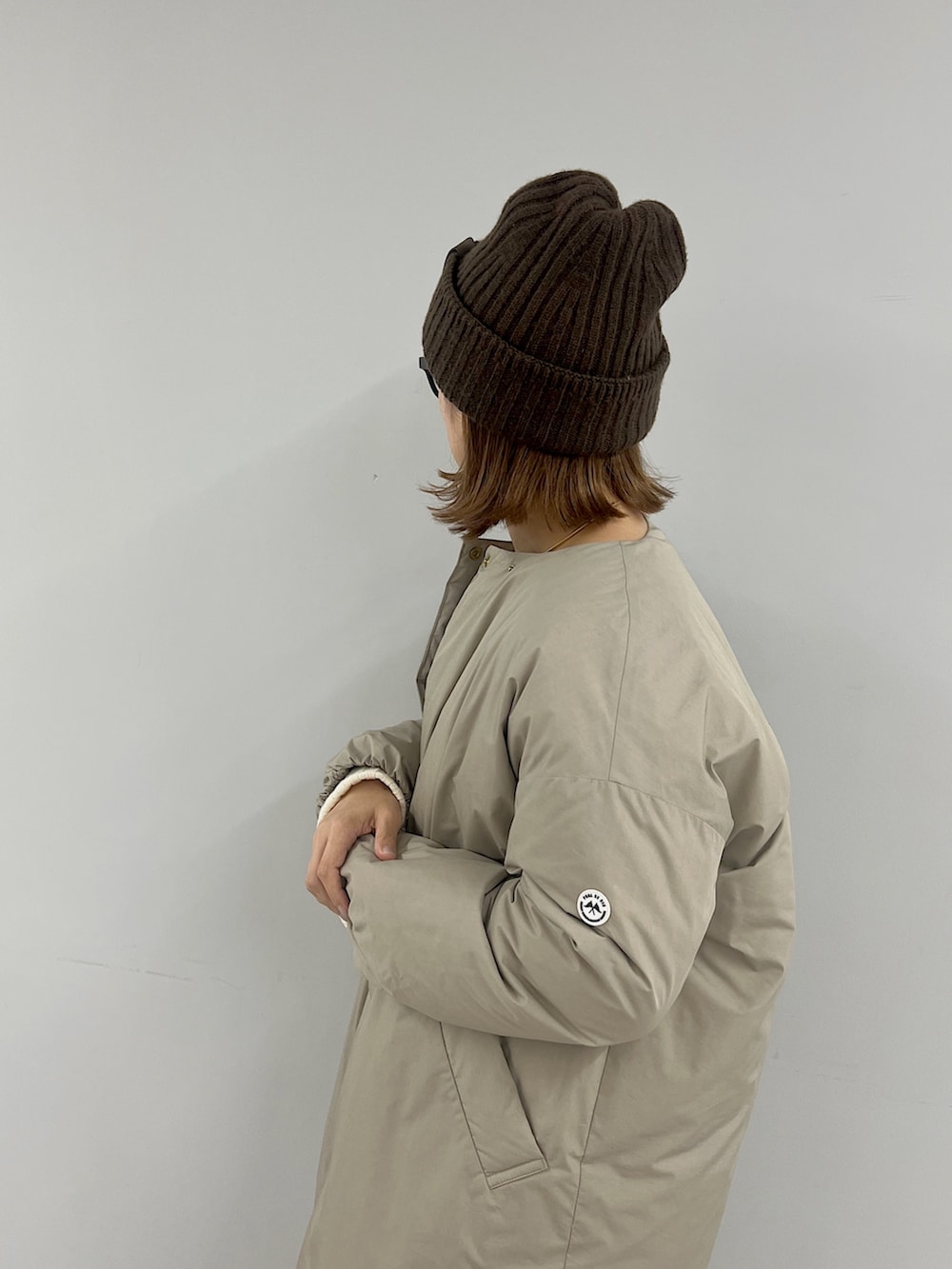 ベージュ系のその他アウター、ホワイト系のカーディガン/ボレロ、ホワイト系のスカートを着用したレディースの冬コーディネートの2枚目の写真