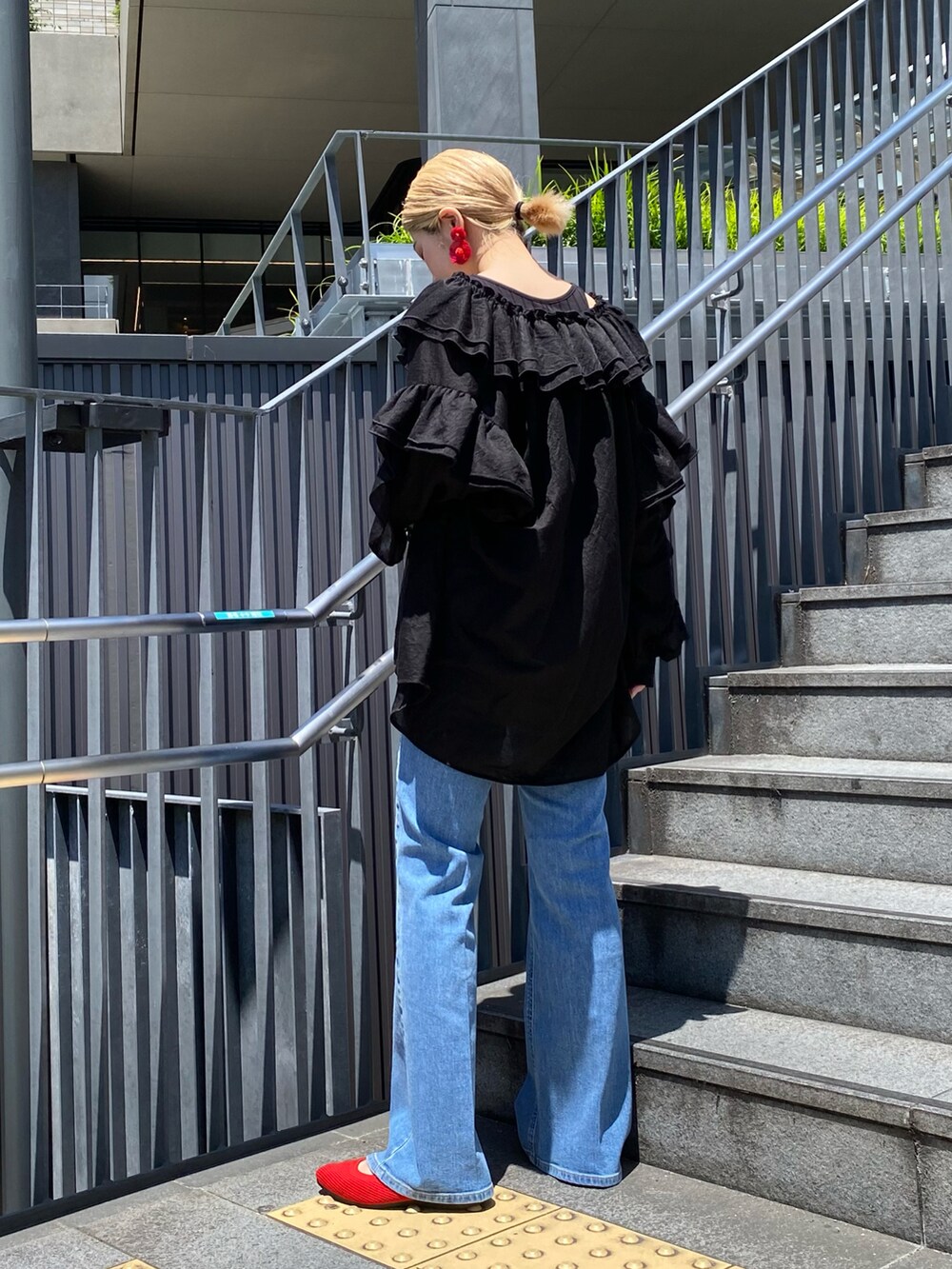 ブルー系のデニムパンツ、ブラック系のシャツ/ブラウスを着用したレディースの秋コーディネートの2枚目の写真