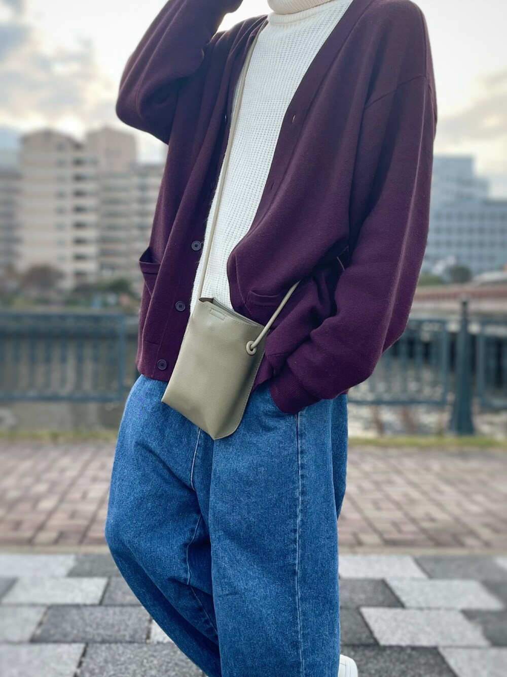 ホワイト系のニット/セーター、グリーン系のショルダーバッグ、レッド系のカーディガン/ボレロを着用したメンズの秋コーディネートの3枚目の写真