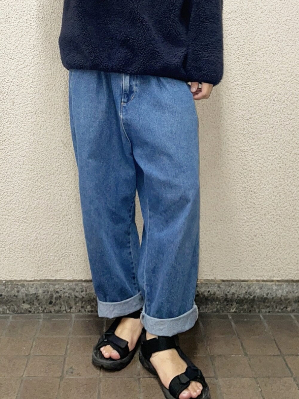 ブルー系のニット/セーター、ブルー系のデニムパンツ、ブラック系のサンダルを着用したメンズの秋コーディネートの2枚目の写真