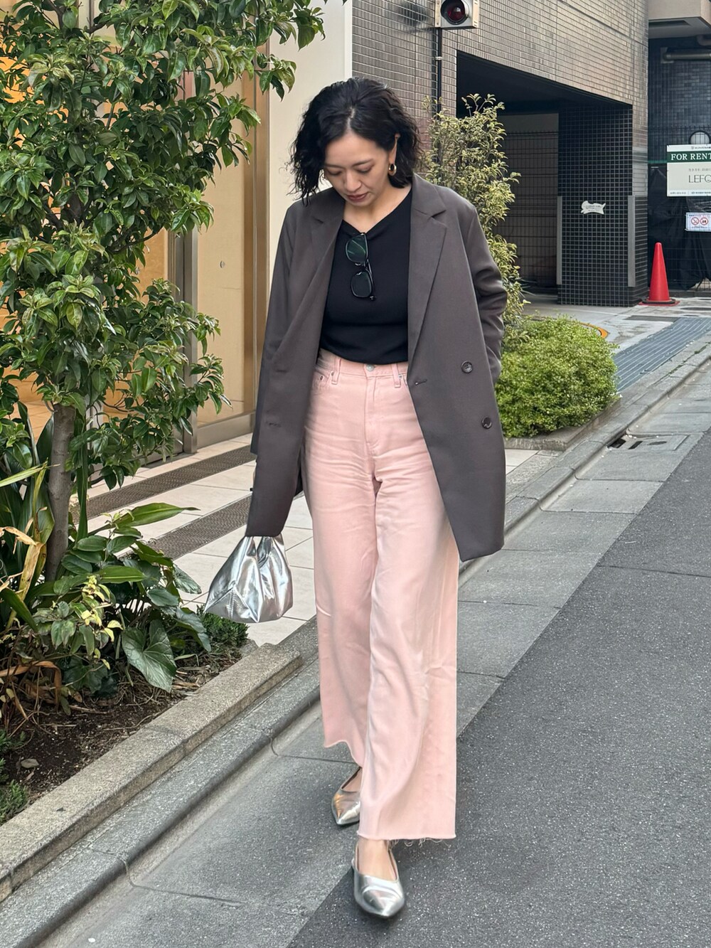 ピンク系のデニムパンツ、シルバー系のシューズ、グレー系のテーラードジャケットを着用したレディースの春コーディネートの2枚目の写真