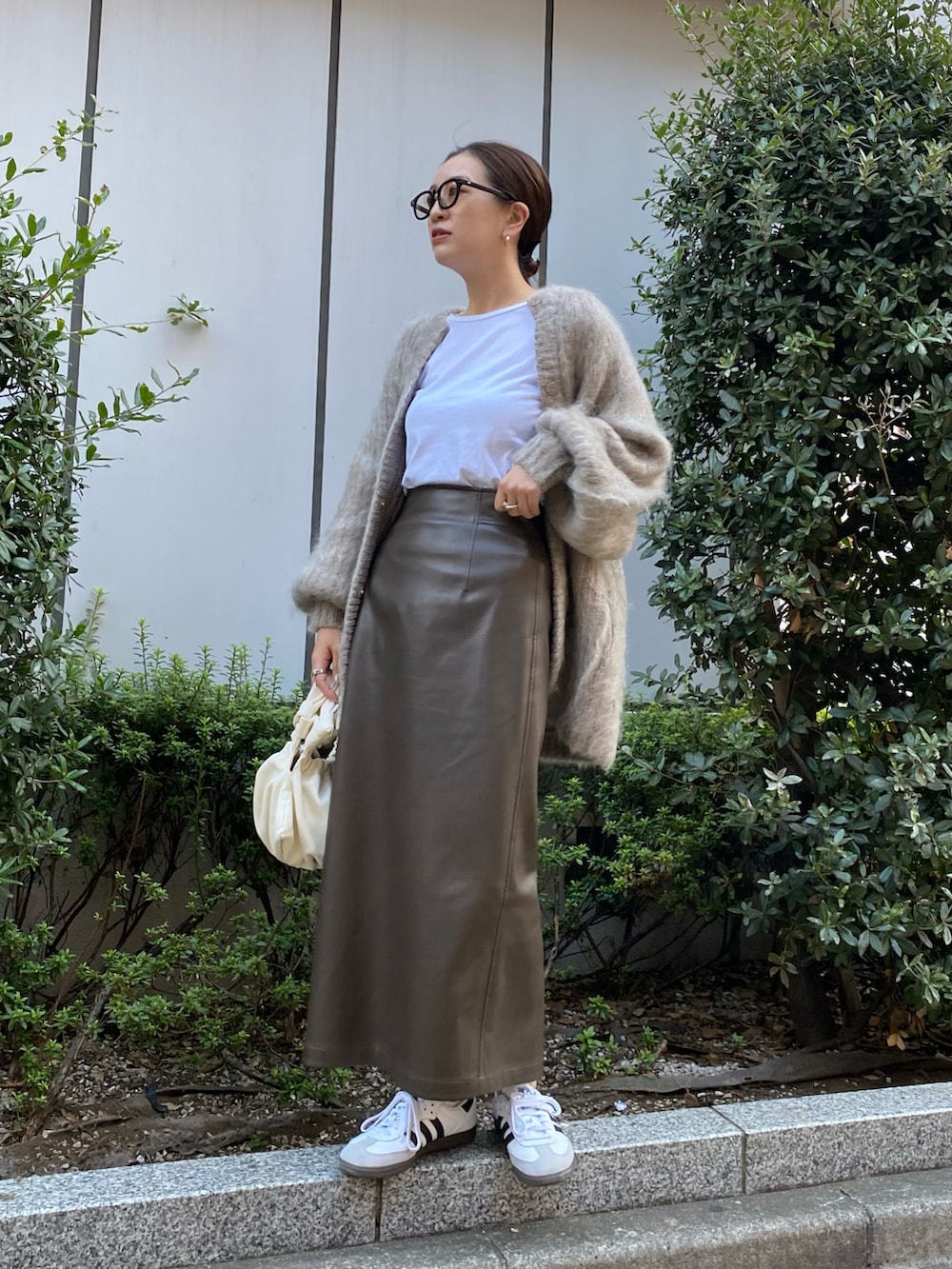 ホワイト系のハンドバッグ、ホワイト系のTシャツ/カットソー、ブラウン系のスカートを着用したレディースの秋コーディネートの2枚目の写真