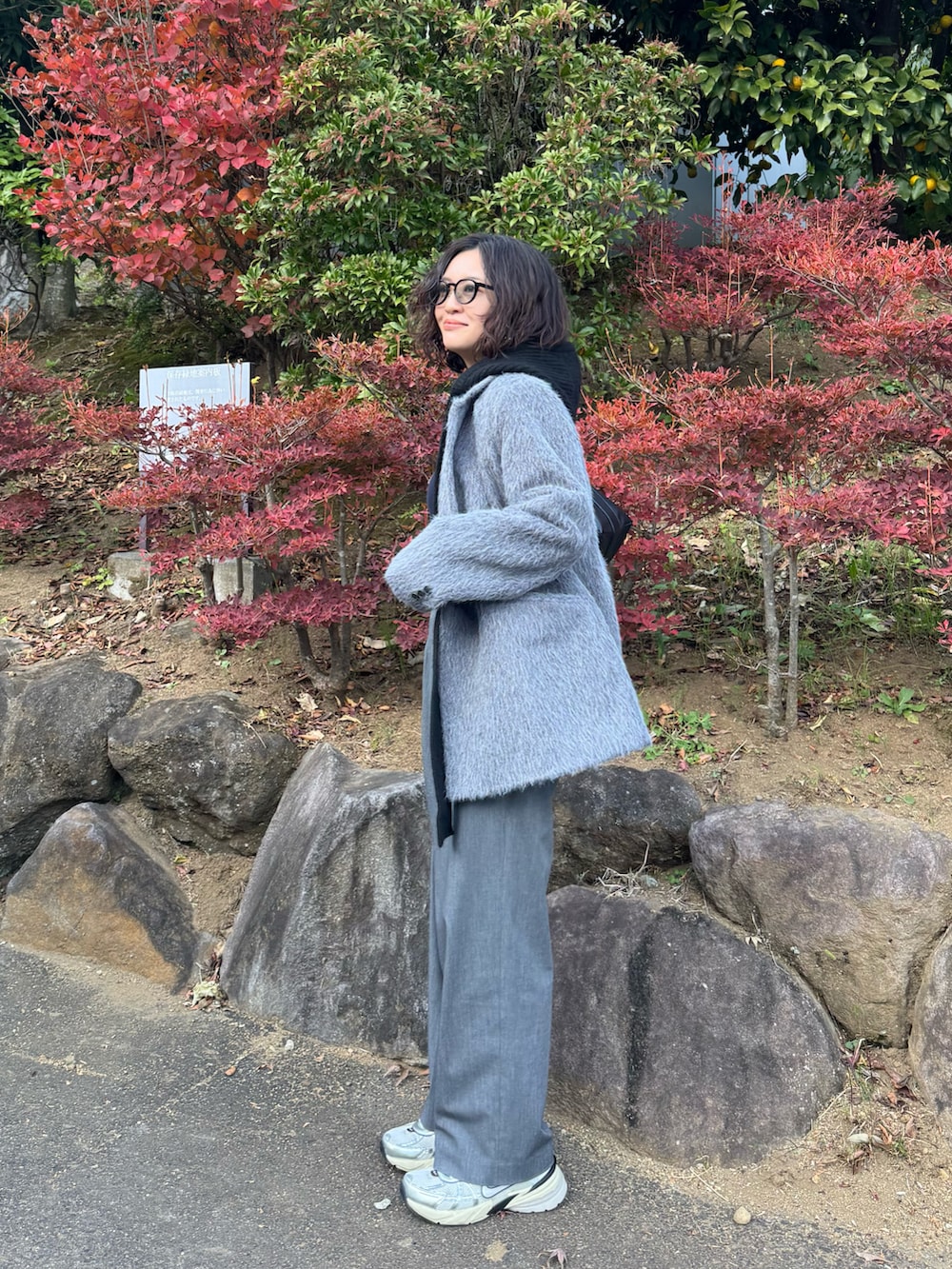 グレー系のテーラードジャケット、グレー系のパンツ、ホワイト系のスニーカーを着用したレディースの冬コーディネートの2枚目の写真