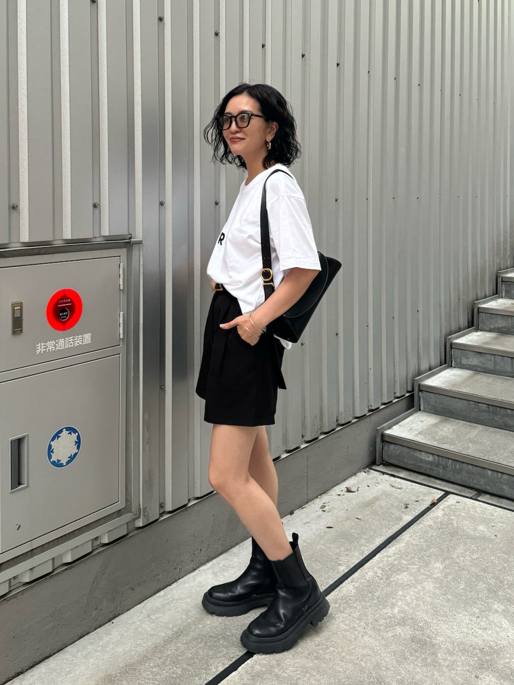 ブラック系のパンツ、ホワイト系のTシャツ/カットソー、ブラック系のショルダーバッグを着用したレディースの夏コーディネートの2枚目の写真