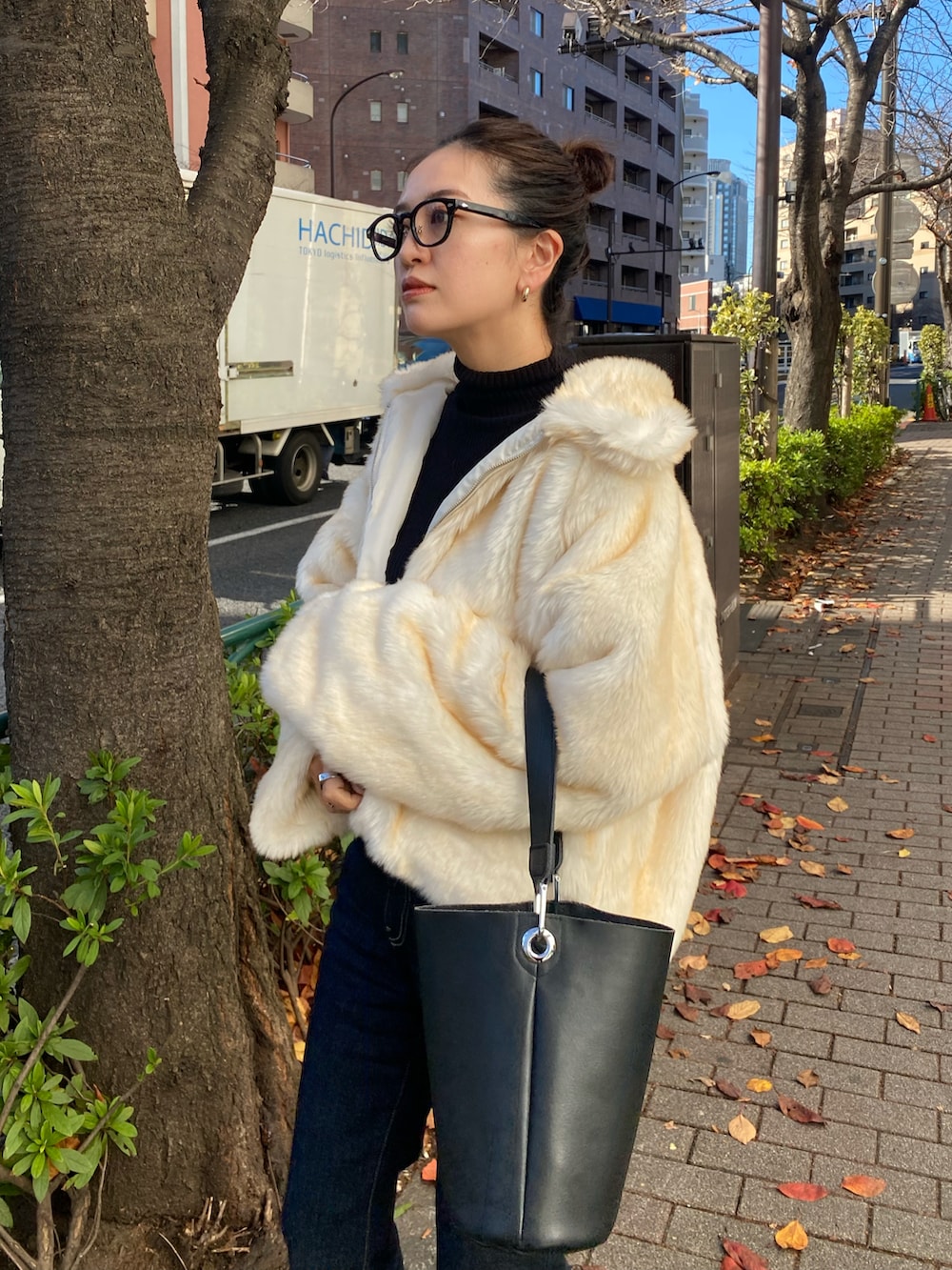 ブルー系のデニムパンツ、ホワイト系のブルゾン、ブラック系のニット/セーターを着用したレディースの冬コーディネートの2枚目の写真