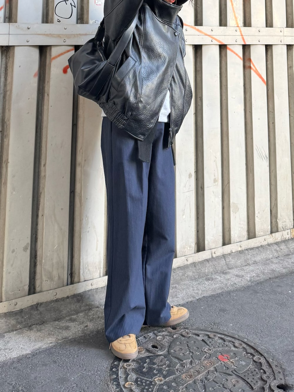 ブルー系のパンツ、ベージュ系のスニーカー、ブラック系のジャケット/アウターを着用したレディースの冬コーディネートの3枚目の写真