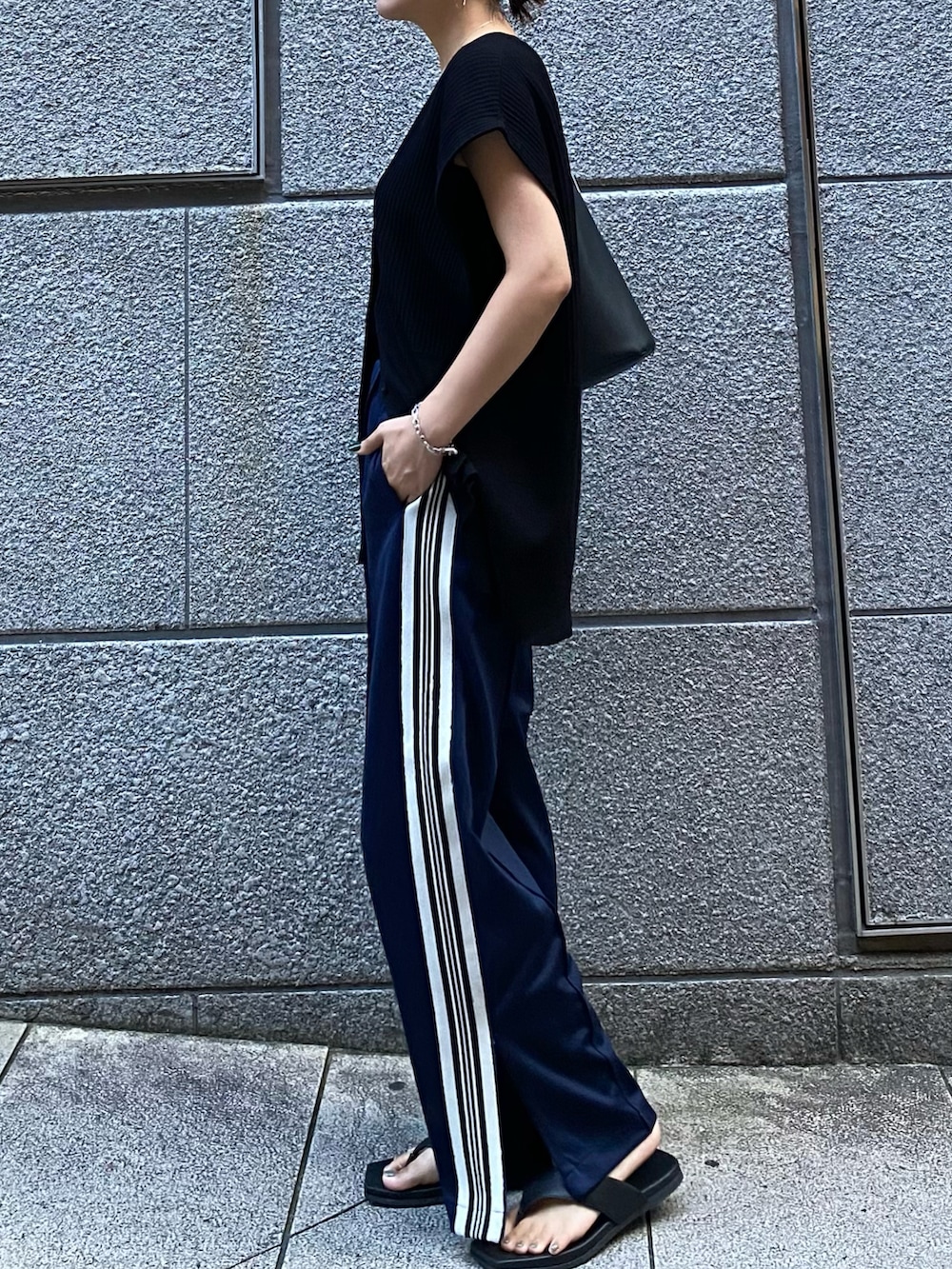 ブラック系のベスト、ブルー系のその他パンツ、ブラック系のサンダルを着用したレディースの夏コーディネートの2枚目の写真