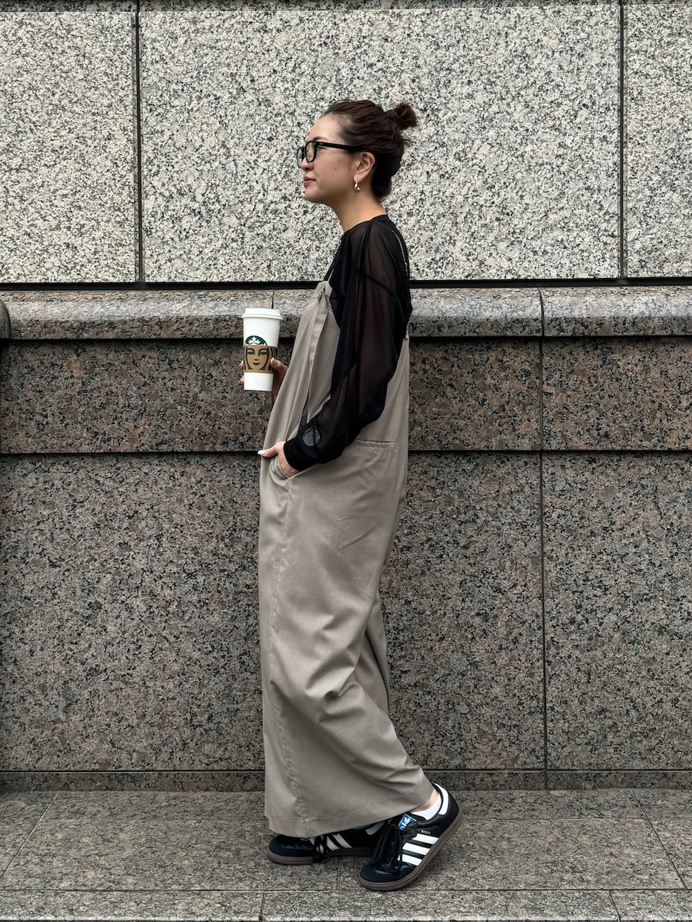 ブラック系のスニーカー、ベージュ系のつなぎ/オールインワン、ブラック系のTシャツ/カットソーを着用したレディースの春コーディネートの2枚目の写真