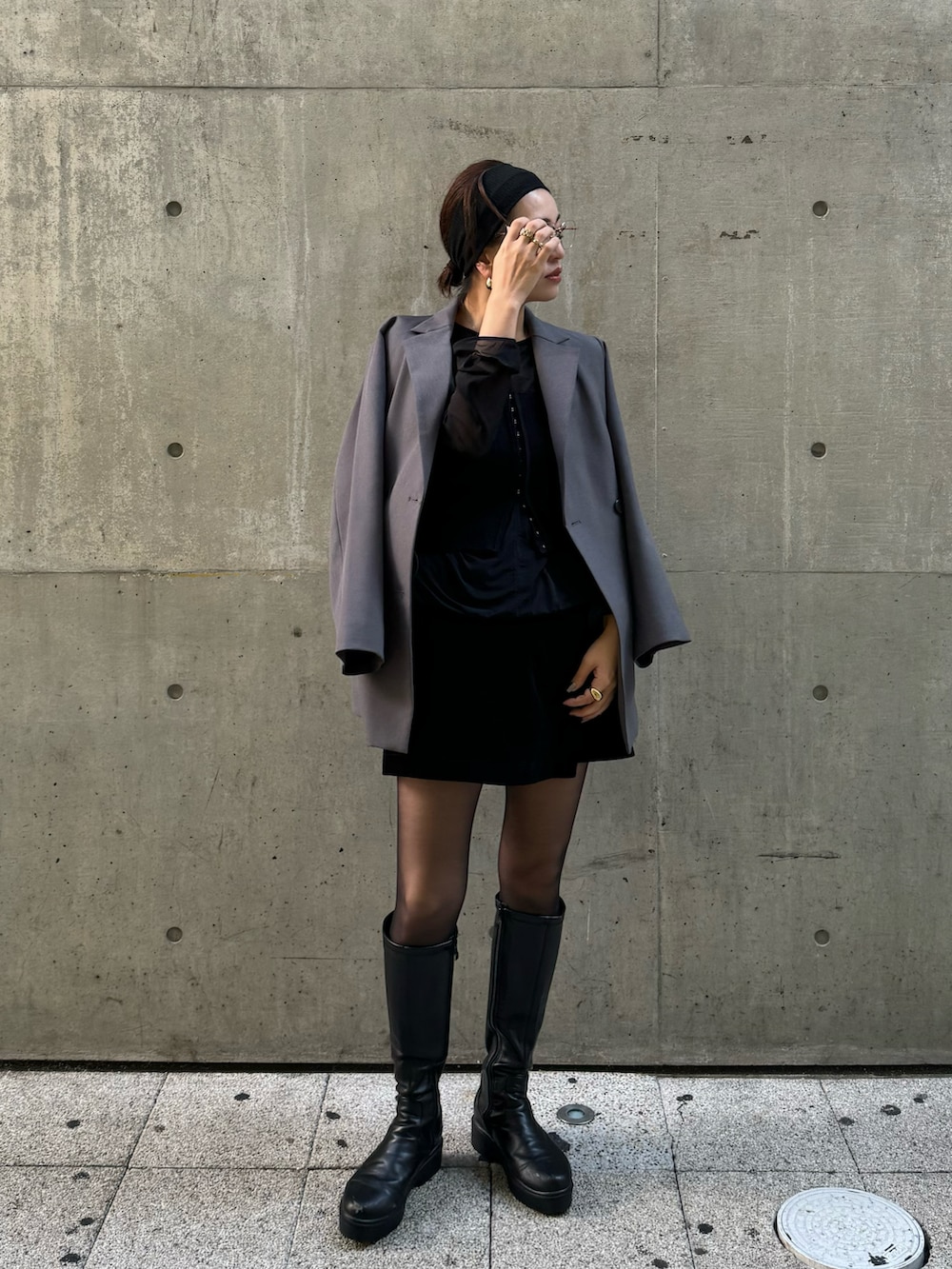 グレー系のテーラードジャケット、ブラック系のパンツ、ブラック系のニット/セーターを着用したレディースの秋コーディネートの2枚目の写真
