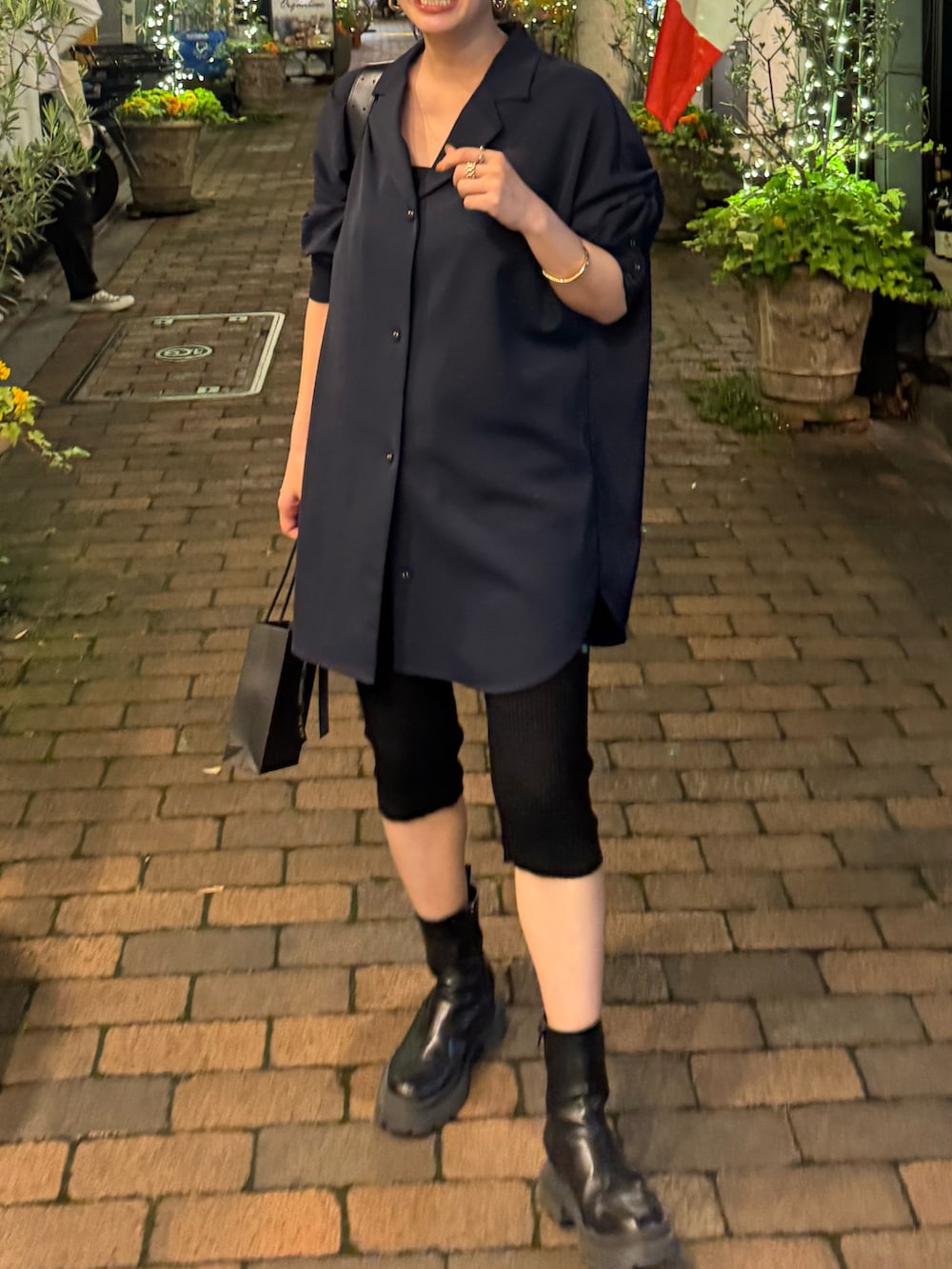 ブラック系のショルダーバッグ、ブルー系のシャツ/ブラウス、ブラック系のブーツを着用したレディースの夏コーディネートの2枚目の写真