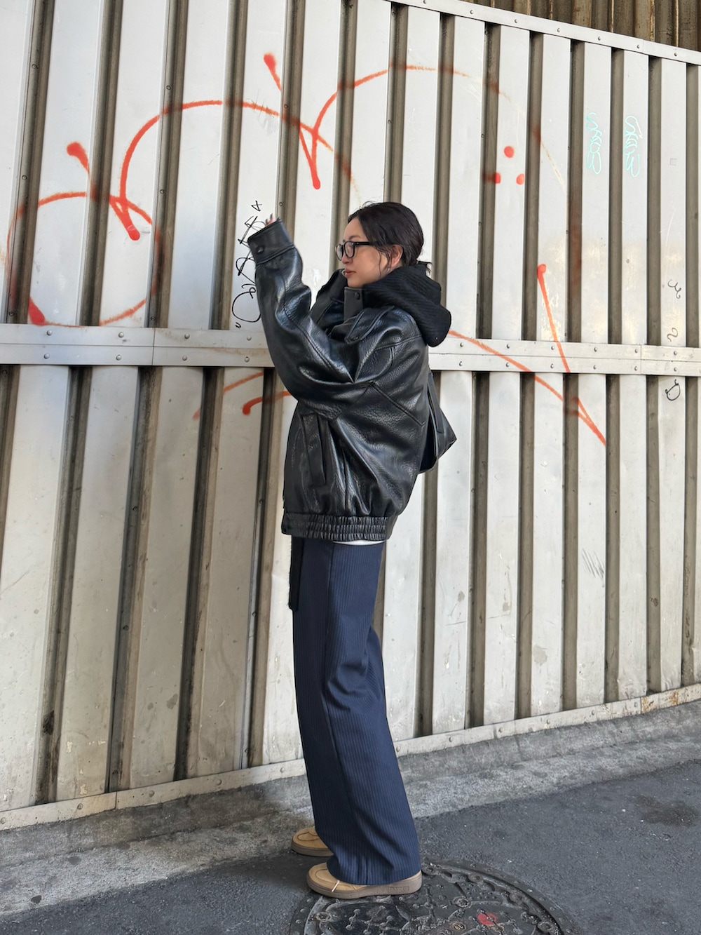 ブルー系のパンツ、ベージュ系のスニーカー、ブラック系のジャケット/アウターを着用したレディースの冬コーディネートの2枚目の写真