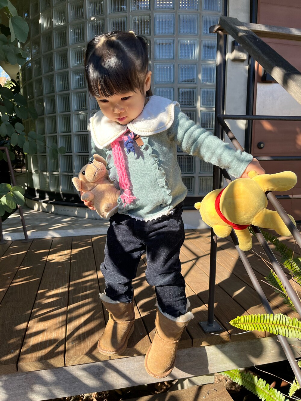 ブルー系のパンツ、ブラウン系のブーツ、グリーン系のニット/セーターを着用したキッズの冬コーディネートの2枚目の写真