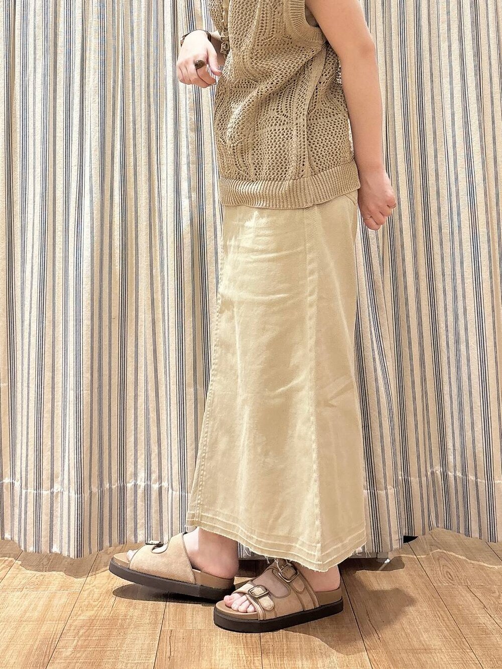 ベージュ系のサンダル、ベージュ系のベスト、ベージュ系のスカートを着用したレディースの夏コーディネートの4枚目の写真