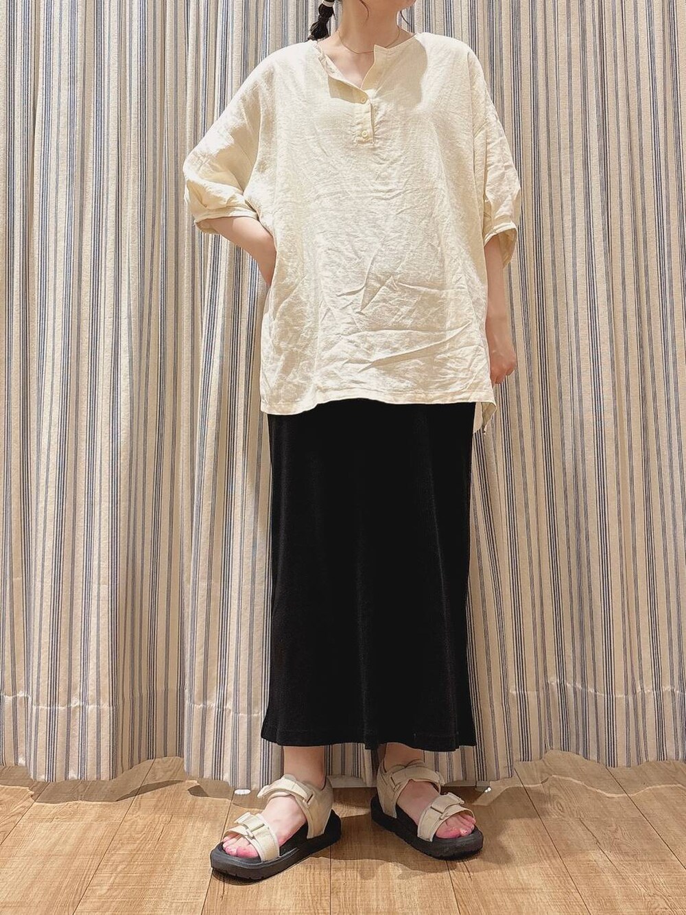 ベージュ系のサンダル、ブラック系のスカート、ベージュ系のシャツ/ブラウスを着用したレディースの夏コーディネートの2枚目の写真