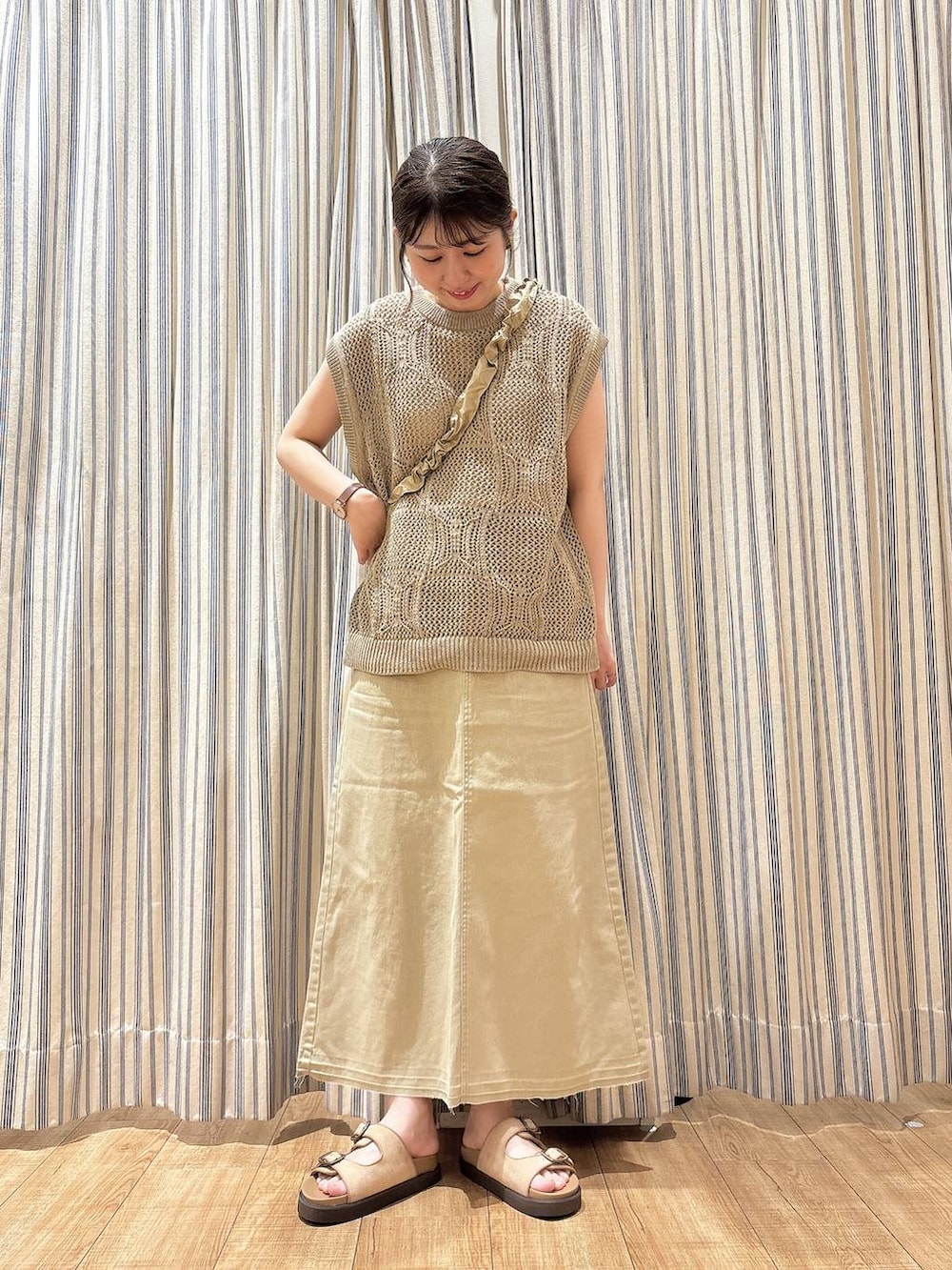 ベージュ系のサンダル、ベージュ系のベスト、ベージュ系のスカートを着用したレディースの夏コーディネートの2枚目の写真