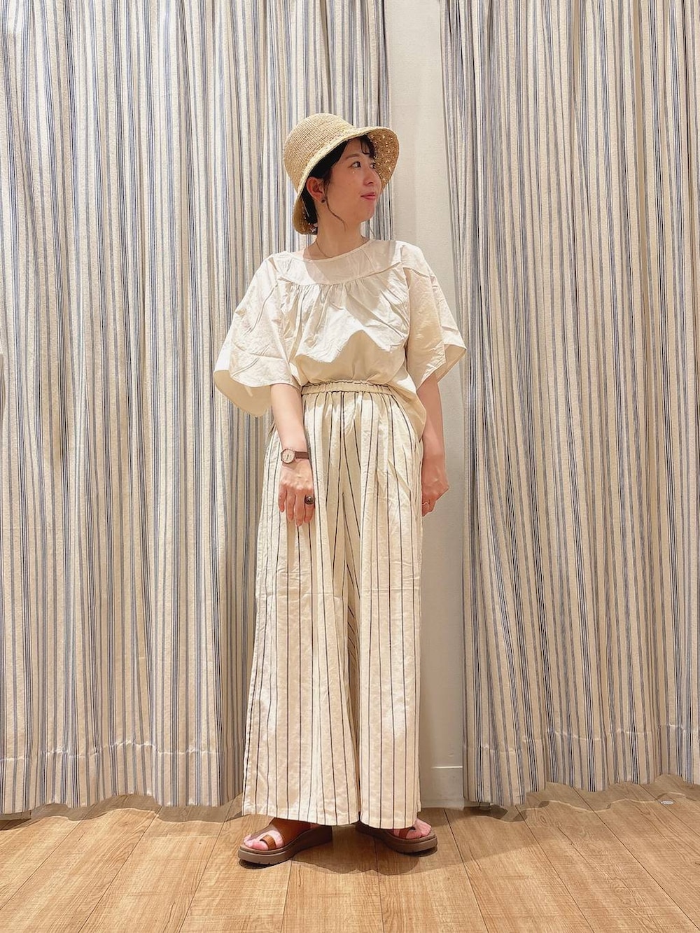 ブラウン系のサンダル、ホワイト系のその他パンツ、ベージュ系のシャツ/ブラウスを着用したレディースの夏コーディネートの2枚目の写真