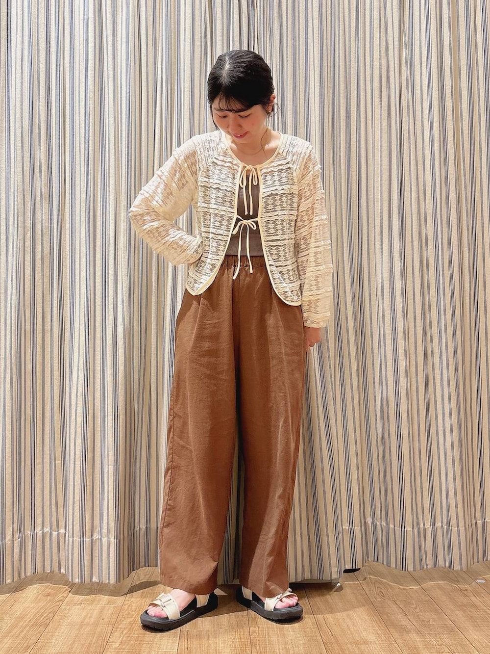 ベージュ系のサンダル、ブラウン系のその他パンツ、ホワイト系のカーディガン/ボレロを着用したレディースの夏コーディネートの2枚目の写真