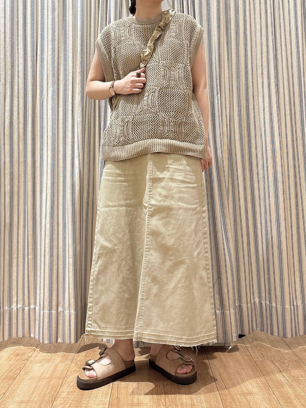 ベージュ系のサンダル、ベージュ系のベスト、ベージュ系のスカートを着用したレディースの夏コーディネートの3枚目の写真