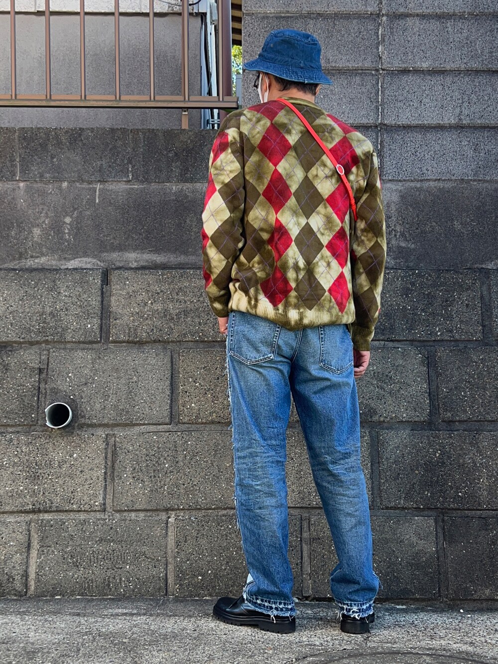 グリーン系のカーディガン/ボレロ、ホワイト系のTシャツ/カットソー、ブラック系のブーツを着用したメンズの秋コーディネートの2枚目の写真